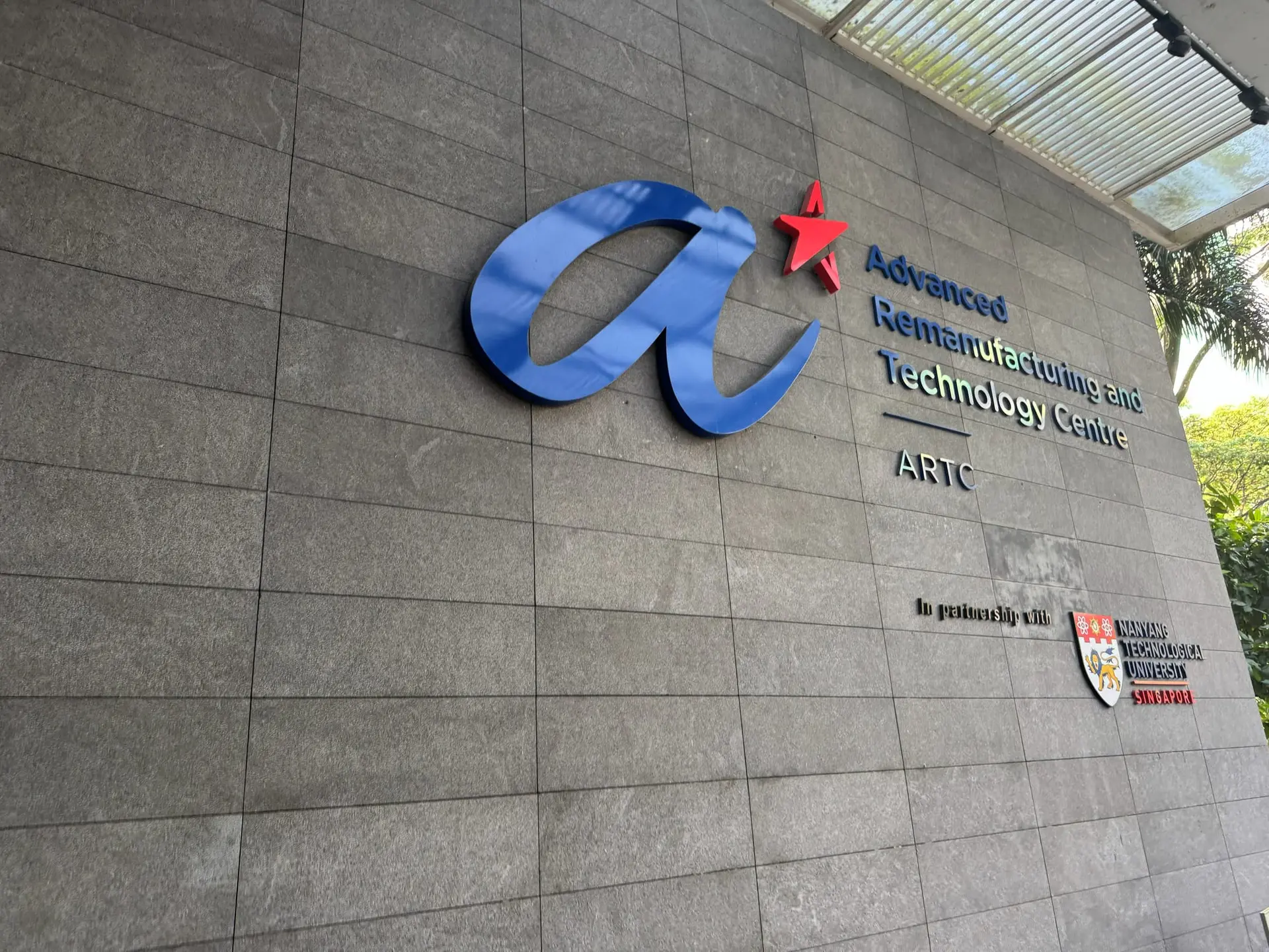 The A*STAR logo and the sign Advanced Remanufacturing and Technology Centre (ARTC), in partnership with NTU, on a stone wall
