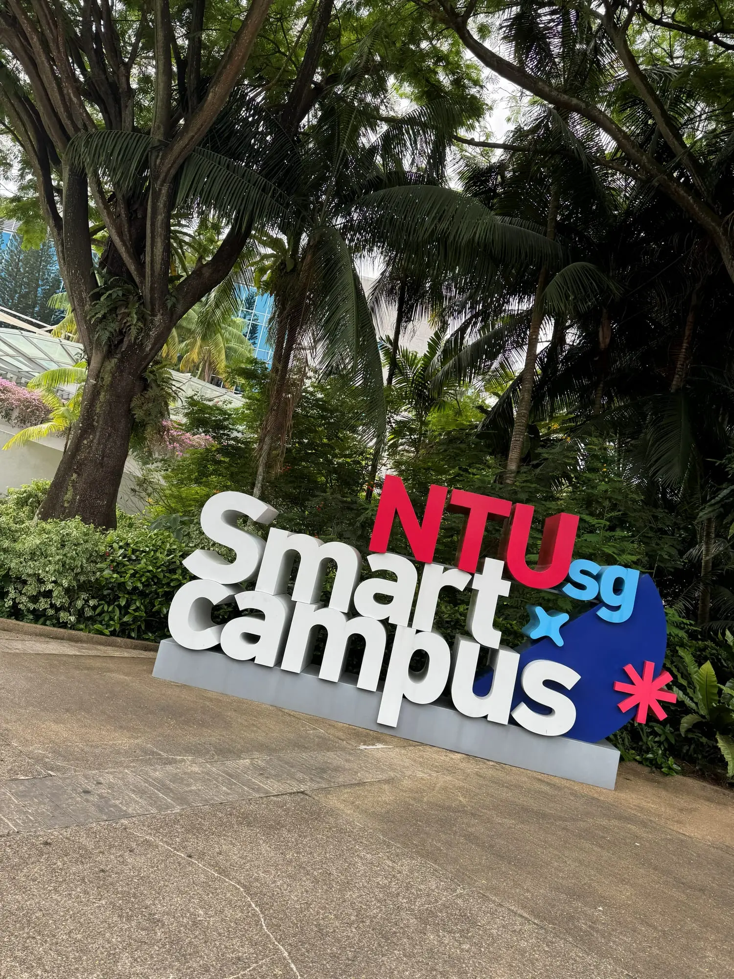 A large NTU Smart Campus sign among tropical trees