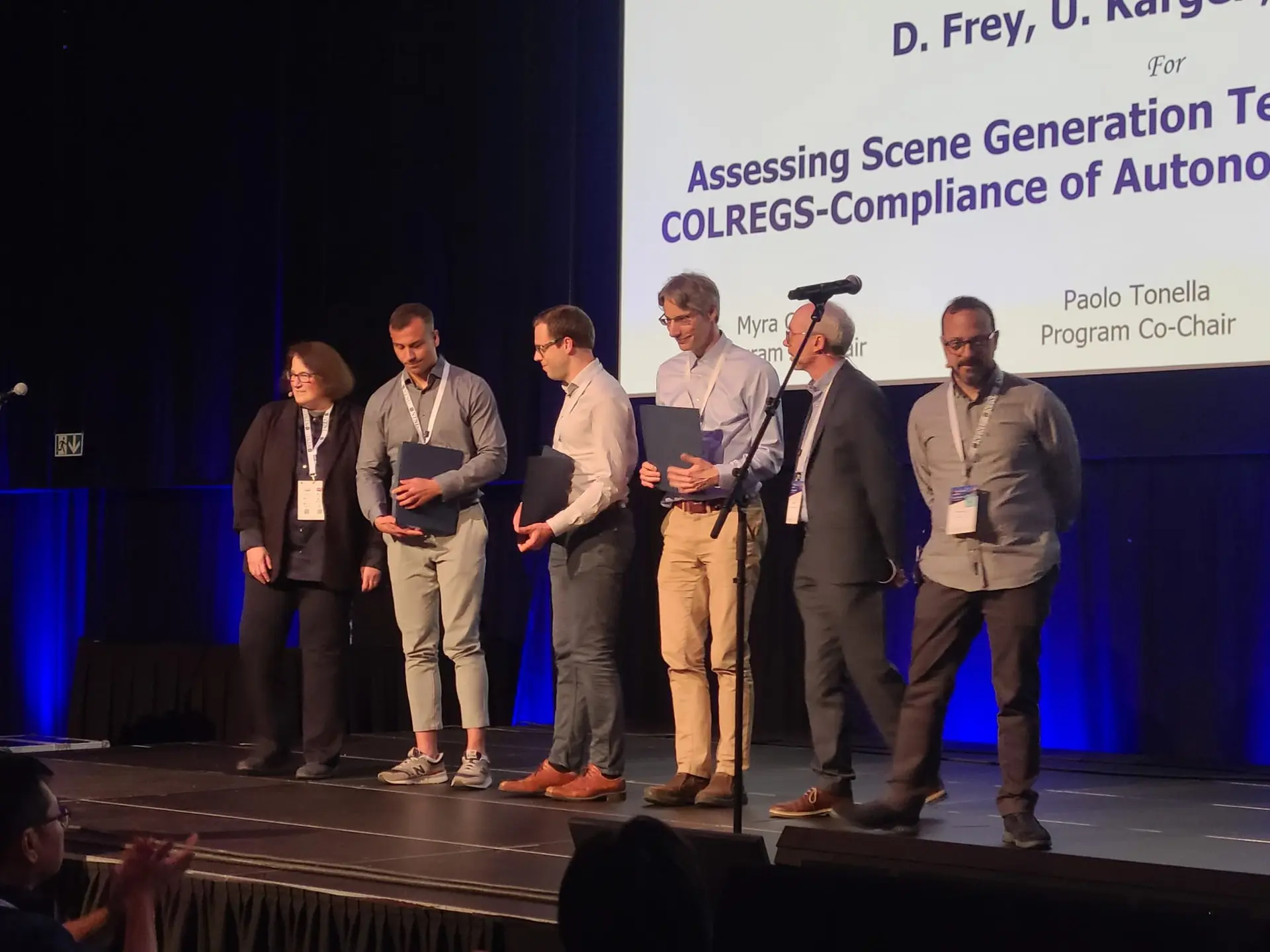 The three authors receiving their certificates on stage at the ISSTA 2025 award ceremony