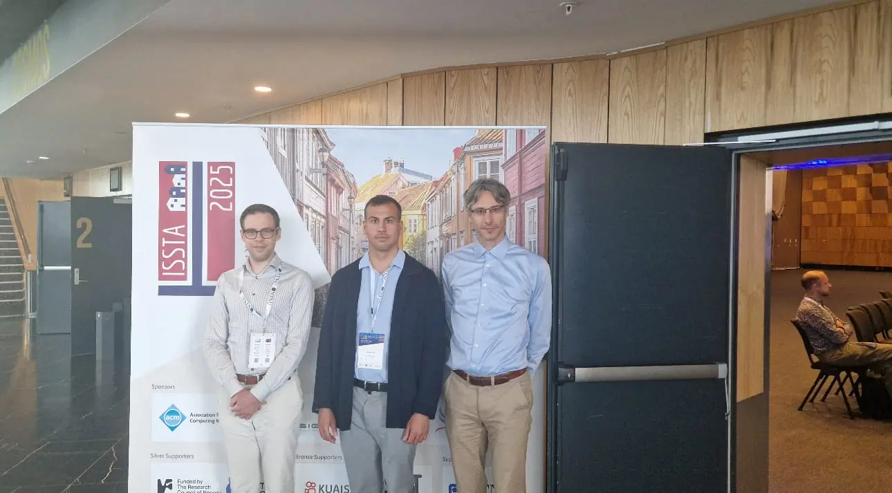 Dominik, Ulf Kargén and Dániel Varró in front of the ISSTA 2025 banner